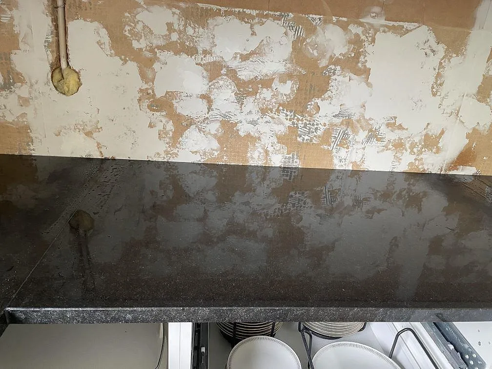 Framkant och blank yta på Nero Assoluto granit, polerad, i ett kök under montering i Falkenberg.