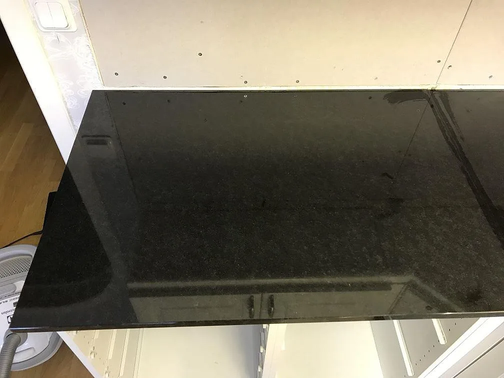Närbild på den polerade ytan på en köksbänkskiva i Nero Assoluto granit i Falköping.