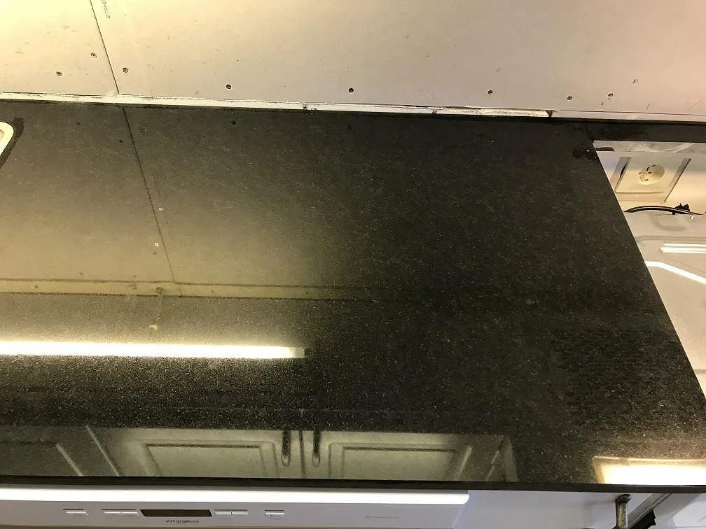 Polerad köksbänkskiva i Nero Assoluto granit med diskho och bänkyta, fotograferad under montering i Falköping.