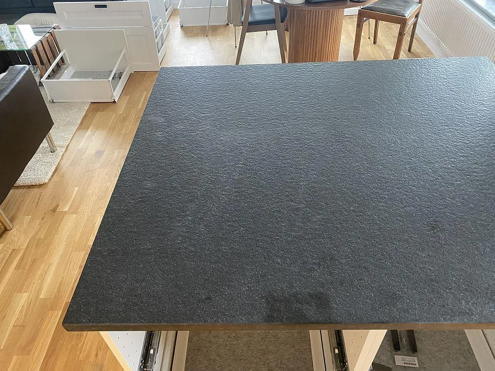 Närbild på köksö i matt Nero Assoluto Flamed and Brushed granit med flammad och borstad yta i Limhamn.
