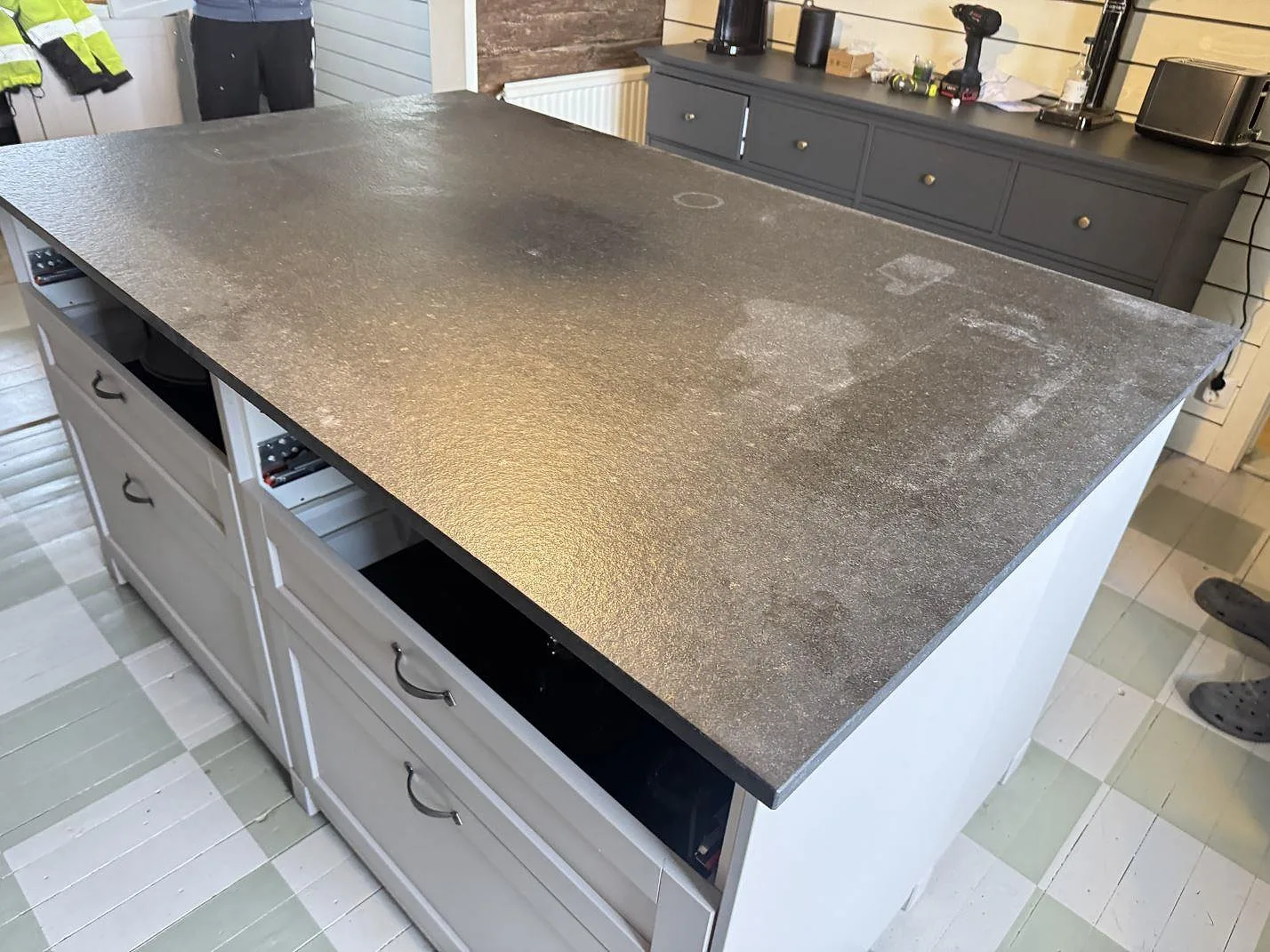 Monterad köksö med Nero Assoluto Flamed and Brushed granit, matt strukturerad yta och köksinredning i Vara.