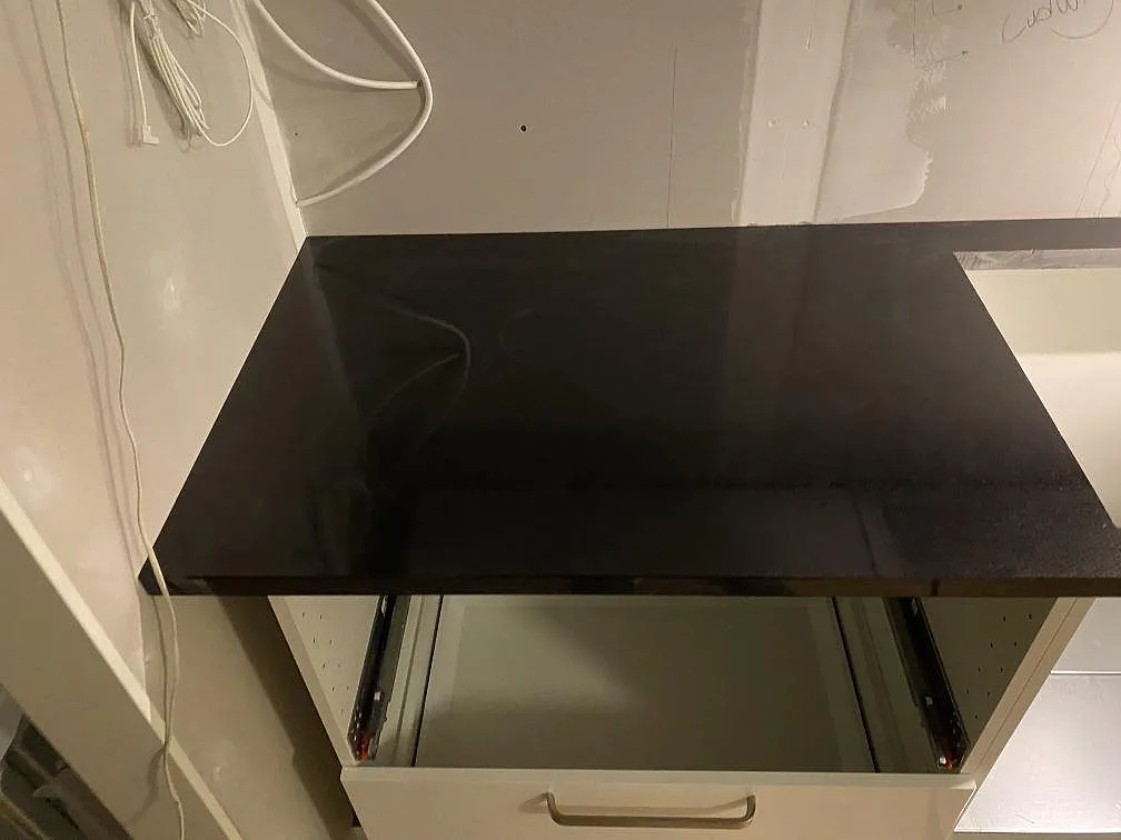 Vänster bänkskiva i polerad Nero Assoluto granit över öppna köksstommar i Hässleholm.