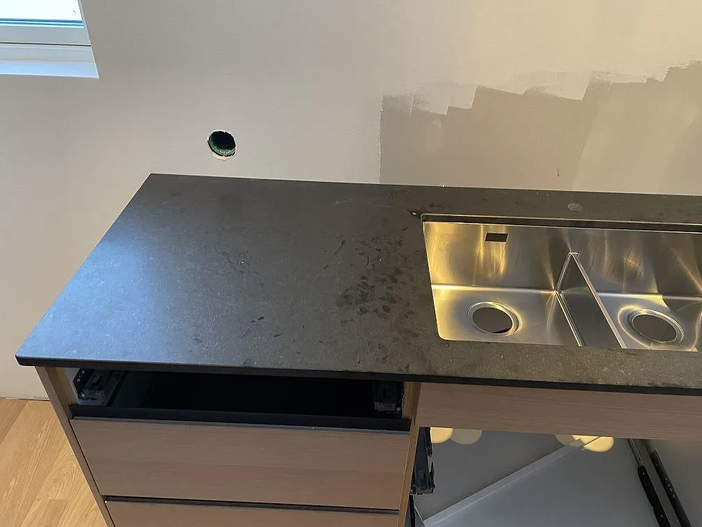 Köksbänkskiva i matt Nero Assoluto granit med rostfri diskho ovanpå stenen i Halmstad.