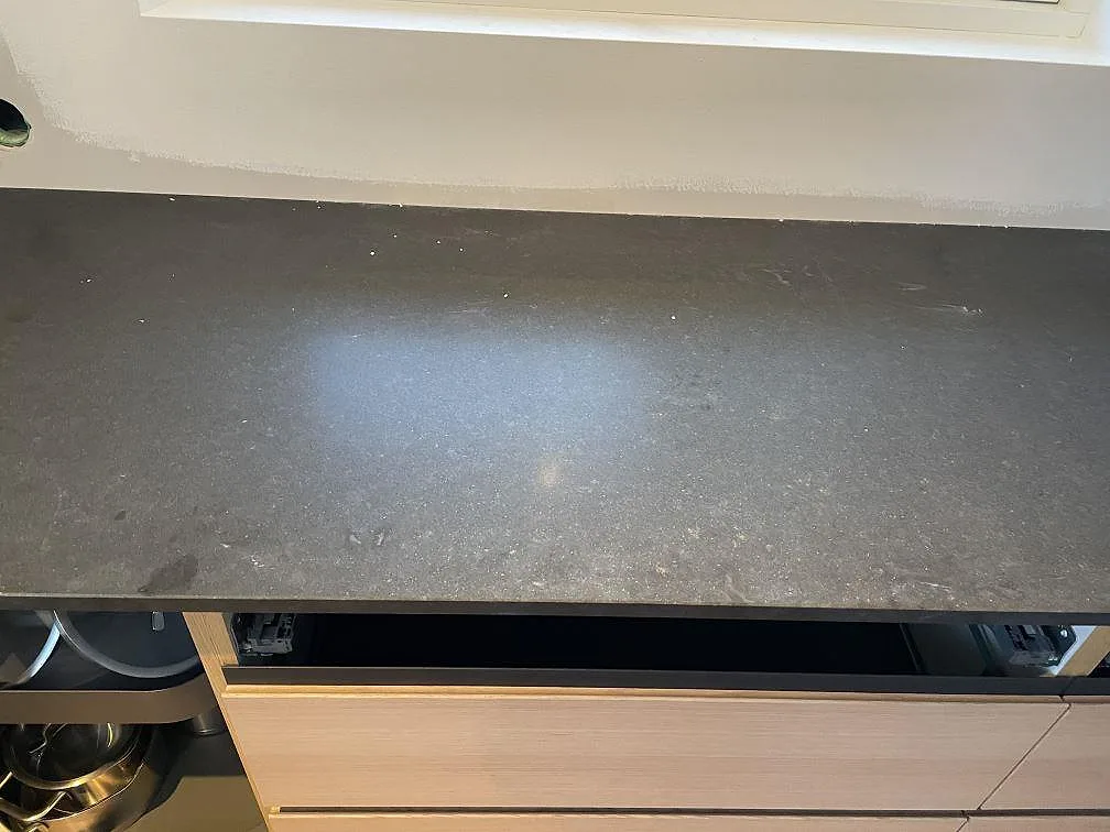 Detalj av matt Nero Assoluto granit på köksbänk under fönster i Halmstad.