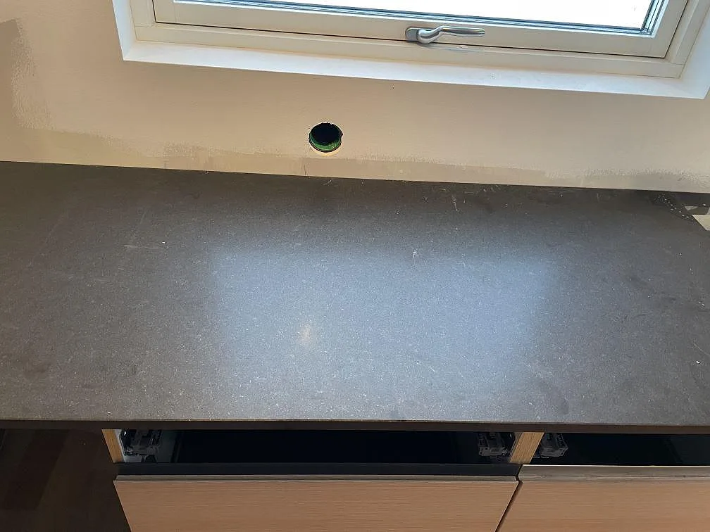 Rak köksbänk under fönster i matt Nero Assoluto granit i Halmstad.