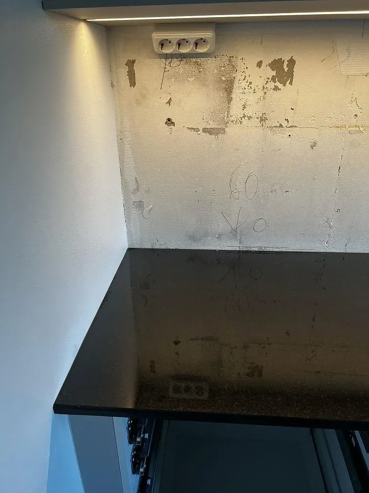 Polerad Nero Assoluto granit vid vägg och bakkant i ett kök under montering i Helsingborg.