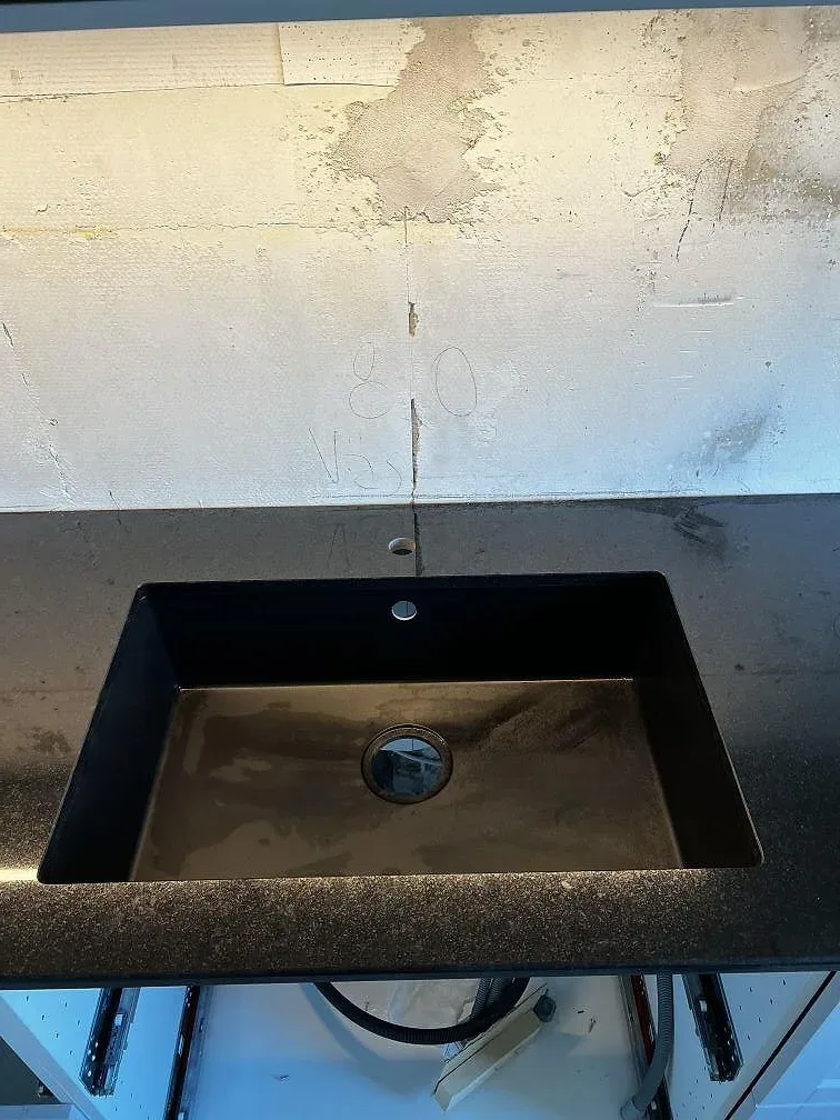 Svart diskho monterad under en polerad Nero Assoluto köksbänkskiva i granit i Helsingborg.