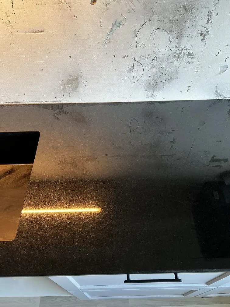 Närbild på polerad Nero Assoluto granit med svart underlimmad diskho och mörk stenyta i Helsingborg.