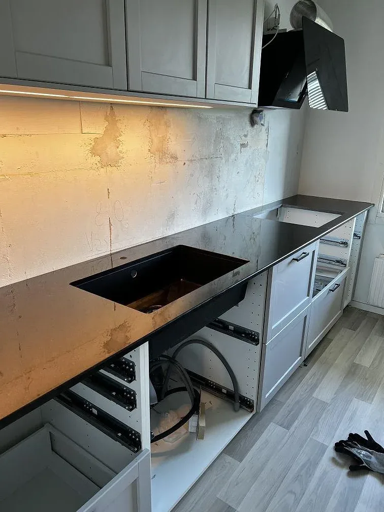 Köksbänkskiva i svart Nero Assoluto granit, polerad, med underlimmad diskho och hällplats i ett kök i Helsingborg.