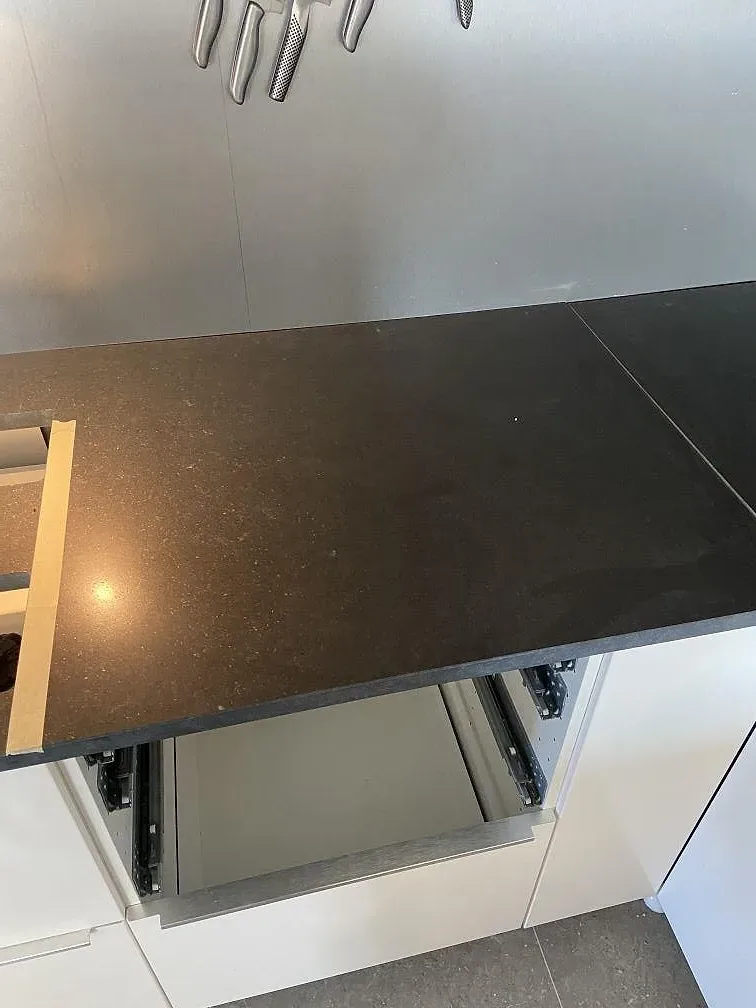 Gavel och sockel på köksbänken i svart Nero Assoluto granit vid en låda med utdragsskenor i ett kök i Huskvarna under montering.