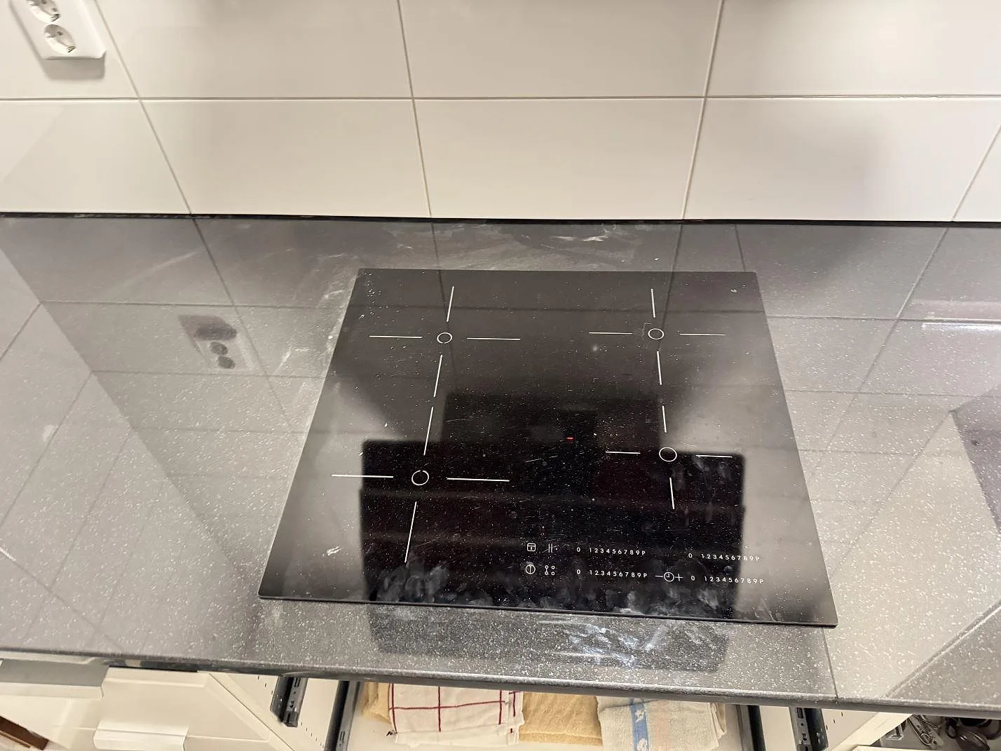Häll monterad i polerad svart Nero Assoluto granit, med kaklad vägg och speglingar i köksbänken i Karlskrona.