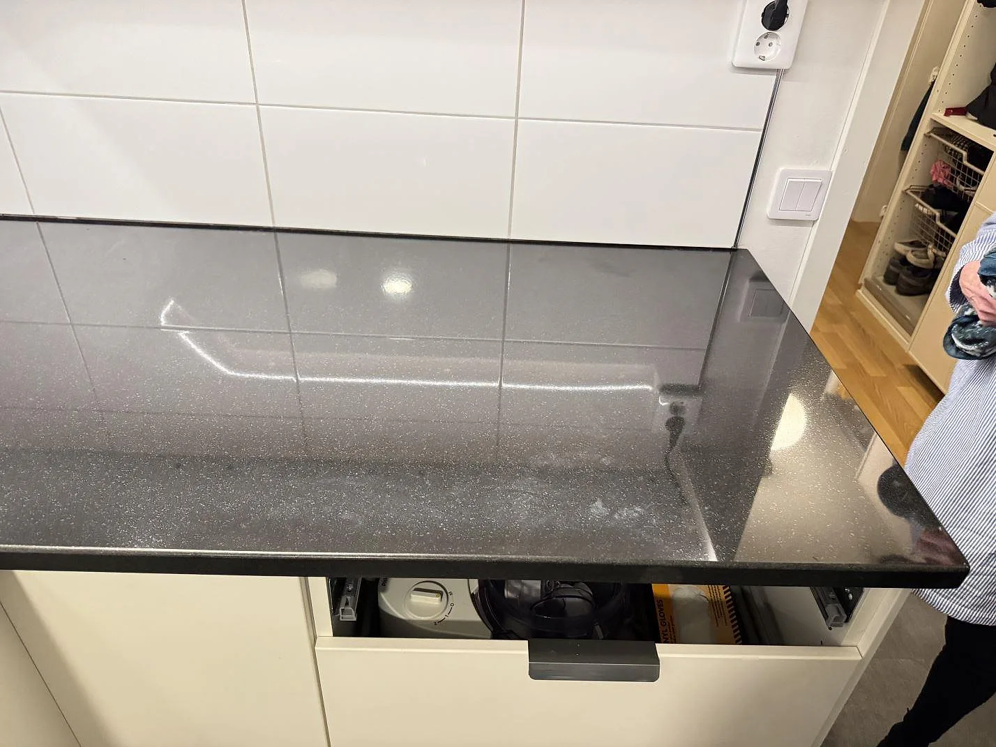 Rak bänkdel i polerad Nero Assoluto granit med mörk spegelblank yta över öppna köksstommar i Karlskrona.