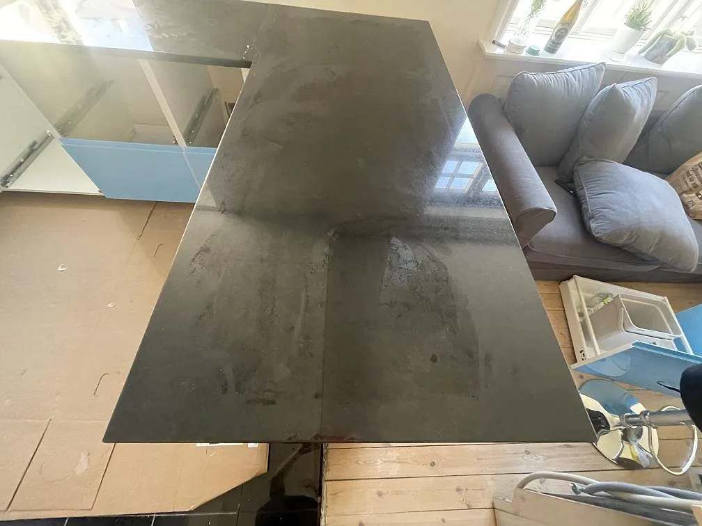 Ovanifrån av en polerad Nero Assoluto granitskiva i svart med spegelblank yta i ett kök i København S.