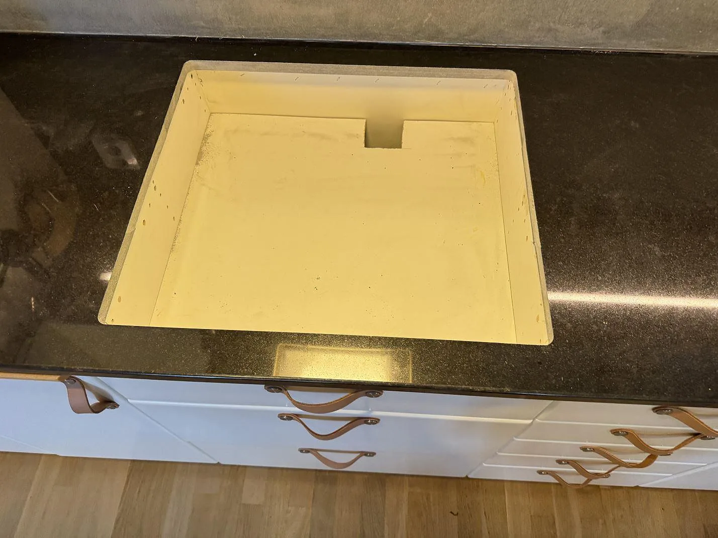 Närbild på rektangulärt urtag i polerad Nero Assoluto granitbänkskiva i ett kök i Kristianstad.