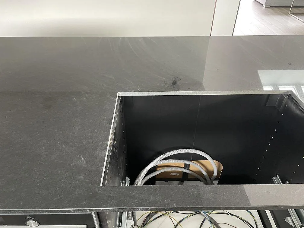 Köksbänk i Nero Assoluto granit med urtag och uppvikt stänkkant under montering i Kungsbacka.