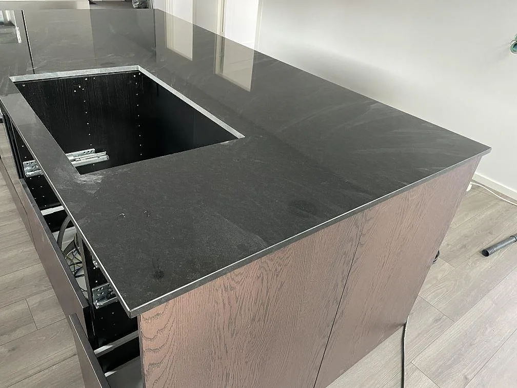 Köksö i polerad Nero Assoluto granit med urtag för underlimmad diskho i ett kök i Kungsbacka.