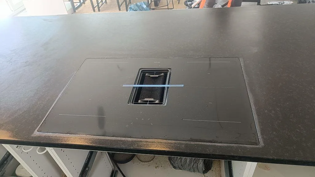 Häll monterad i svart Nero Assoluto granit på köksö med matt leather-finish i Askim.