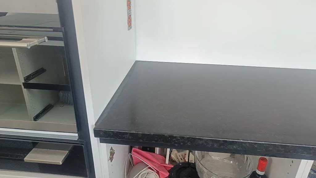 Rak bänkyta i Nero Assoluto granit, matt leather-yta, vid vit köksinredning i Askim.