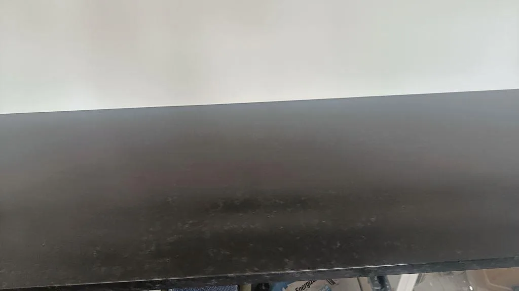 Detaljbild av den matta leather-ytan på Nero Assoluto granitbänkskiva i kök i Askim.