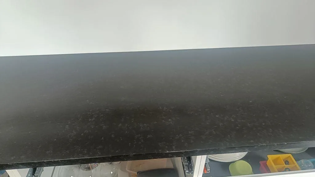 Nära vy över Nero Assoluto granit med matt leather-struktur på köksbänkskiva i Askim.
