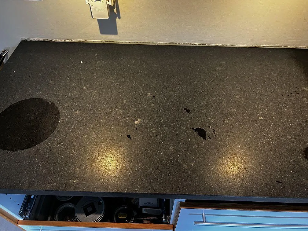 Rak bänkyta i matt Nero Assoluto Leather granit med fin svart struktur i ett kök under montering i Höllviken.