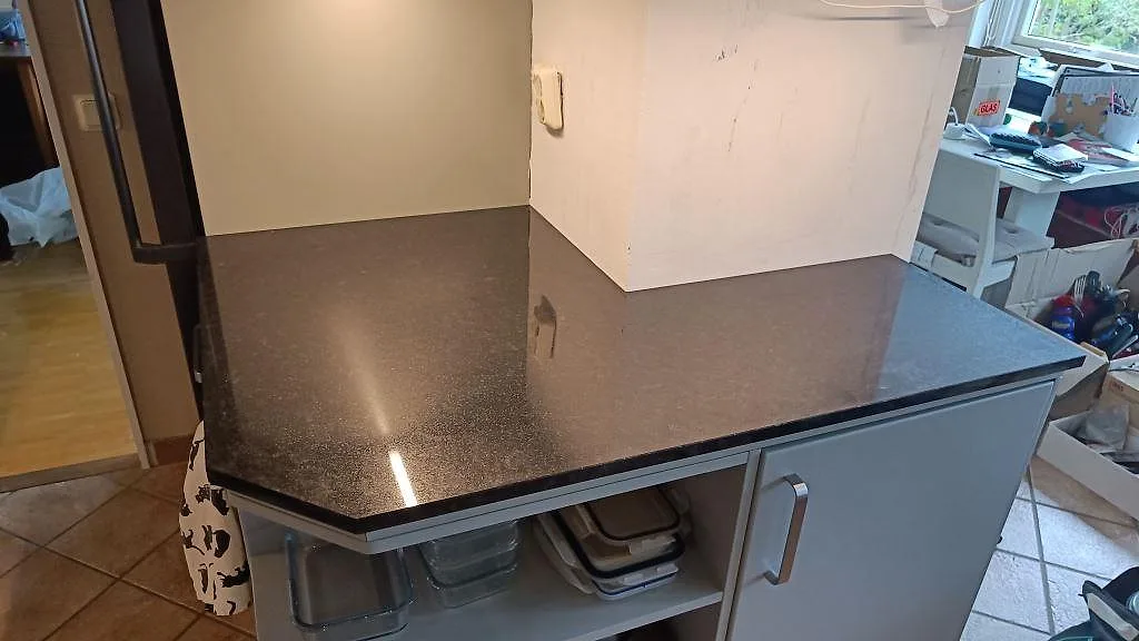 Polerad Nero Assoluto granit på en mindre köksbänk vid väggpartiet i Lomma.