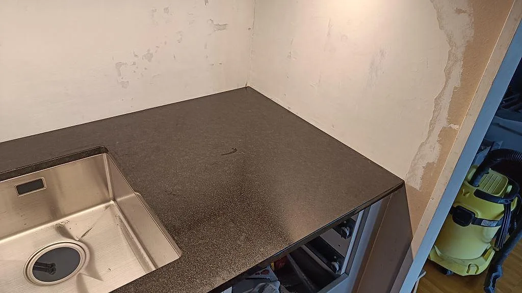 Detalj av polerad Nero Assoluto granit vid diskhon och den högra arbetsytan i köket i Lomma.