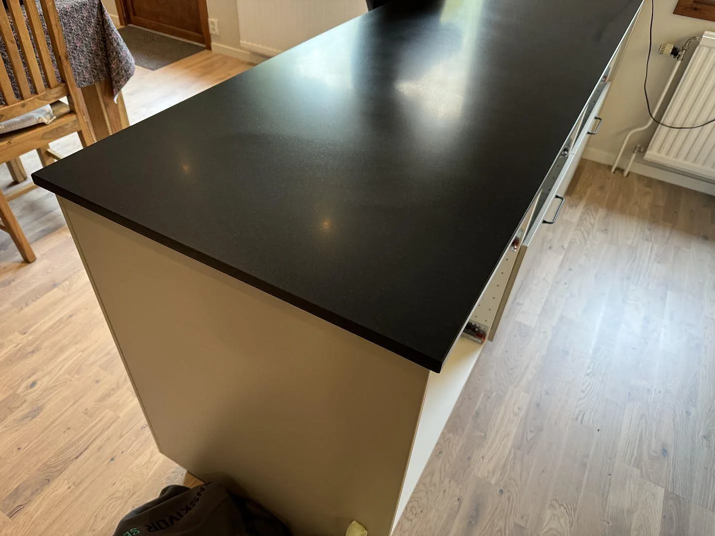 Separat arbetsyta i matt Nero Assoluto granit på köksstomme under montering i Lomma.