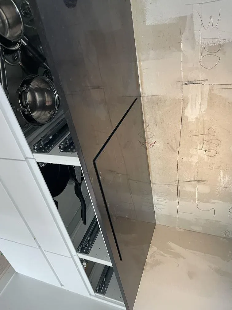 Närbild på svart Nero Assoluto granit, polerad köksbänkskiva över öppna vita köksstommar i Lund.
