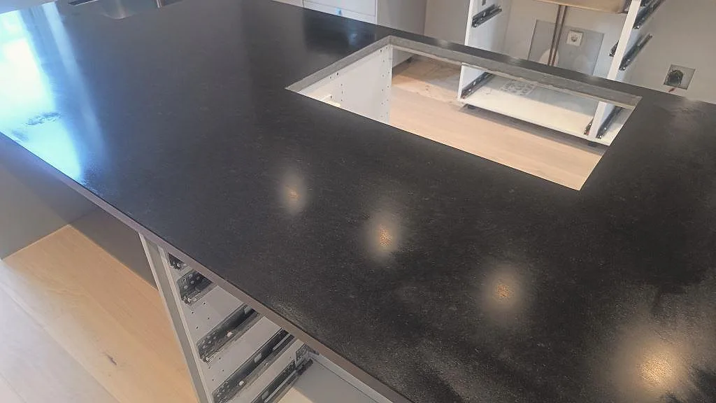 Detalj av svart Nero Assoluto granit i matt finish med stenstruktur och utskärning i köksö i Malmö.