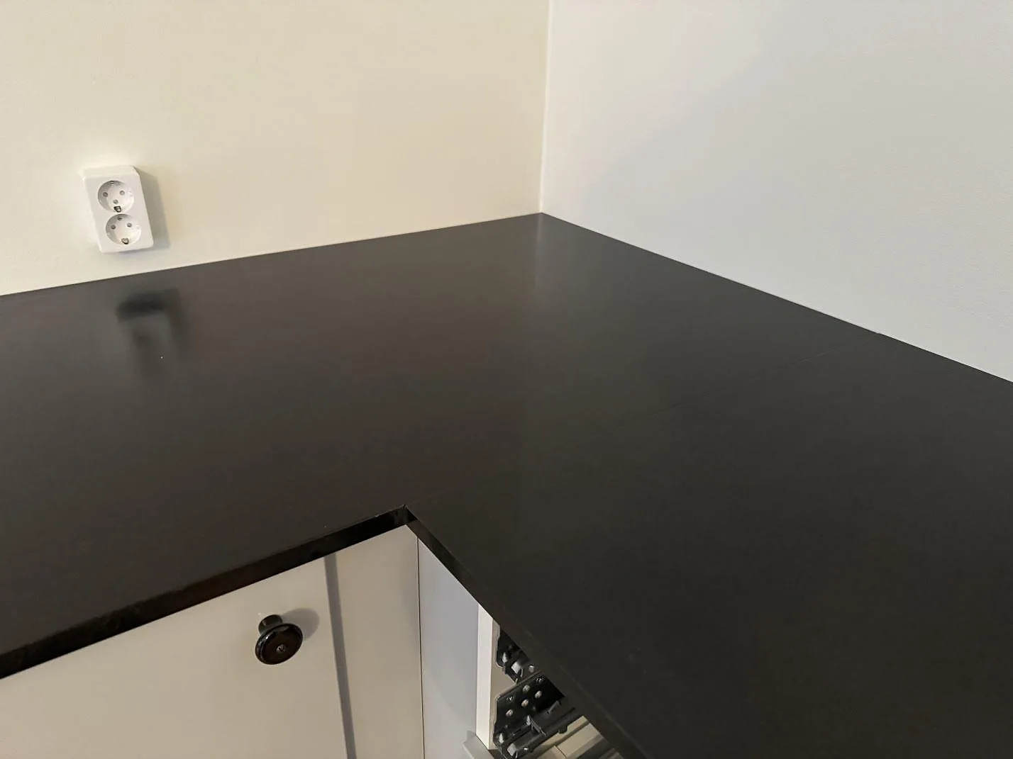 Innerhörn i L-formad köksbänkskiva av matt svart Nero Assoluto granit i Malmö.