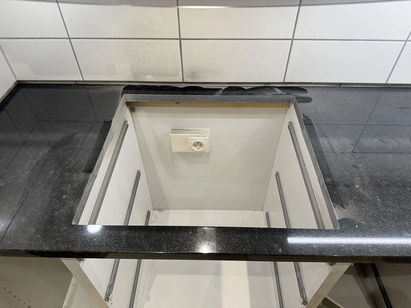 Topvy av polerad Nero Assoluto granit med stor öppning i en köksbänkskiva under montering i Malmö.
