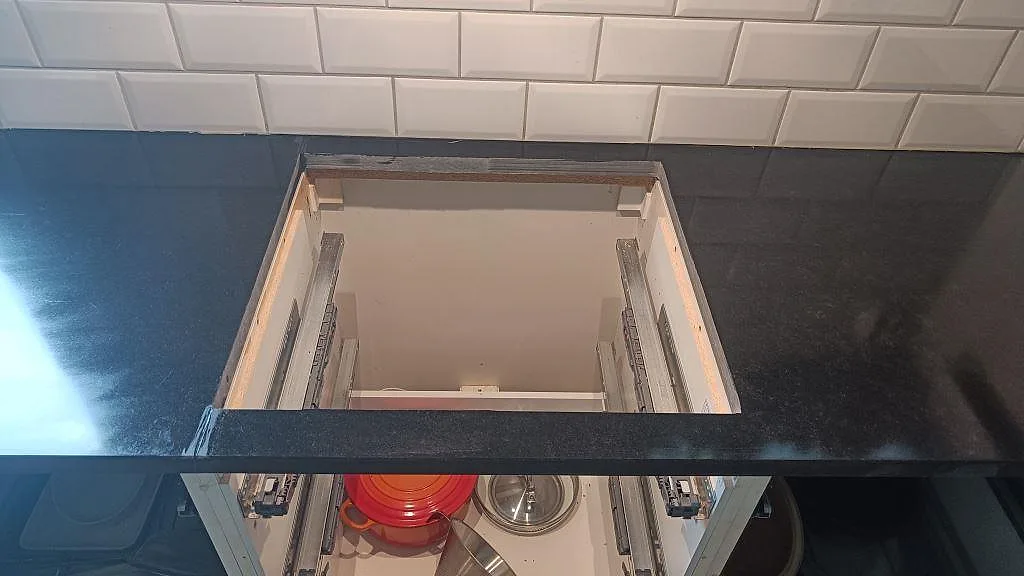 Detalj av hällurtag i matt Nero Assoluto granit under fläktkåpan i ett kök i Malmö.