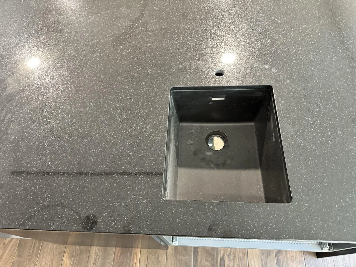 Detalj av fyrkantigt urtag och blank finprickig Nero Assoluto granit i köksbänkskivan i Oxie.