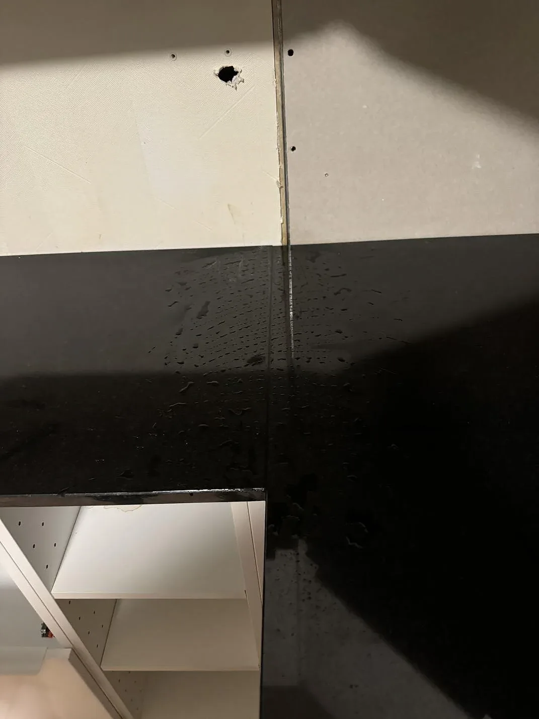 Detalj av polerad Nero Assoluto granit vid hörn och öppna köksstommar i Oxie.