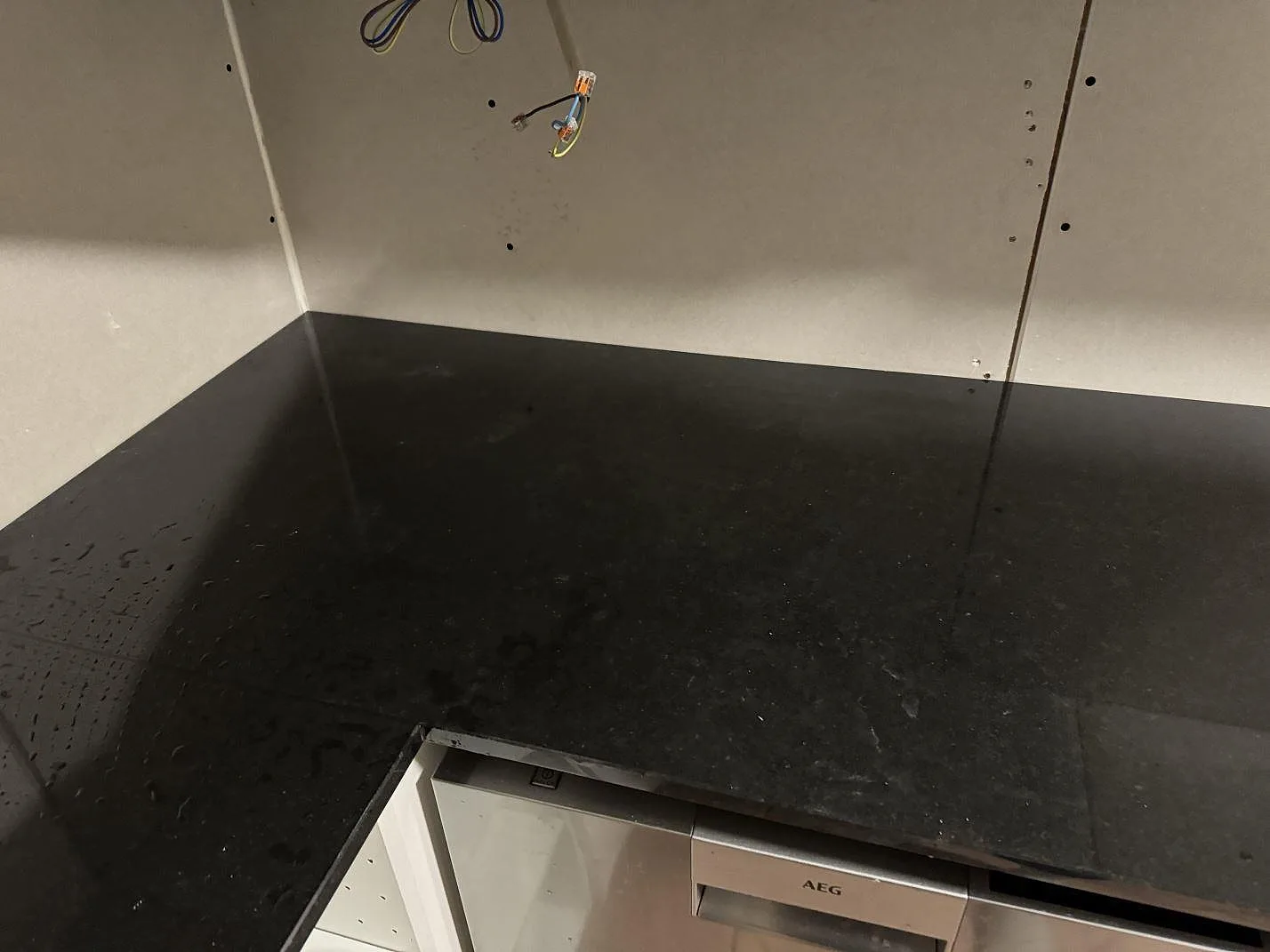 Blank köksbänkskiva i Nero Assoluto granit med öppning för häll under montering i Oxie.