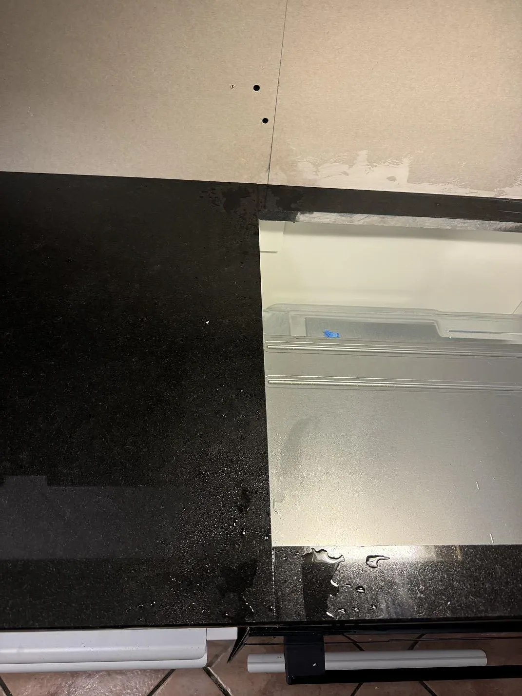 Polerad Nero Assoluto granit med hällöppning och blank svart arbetsyta i ett kök i Oxie.