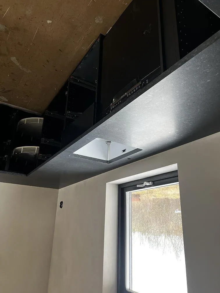 Köksbänkskiva i svart matt Nero Assoluto-granit med infälld induktionshäll och nedsänkt fönsterbänk i ett kök i Senoren.