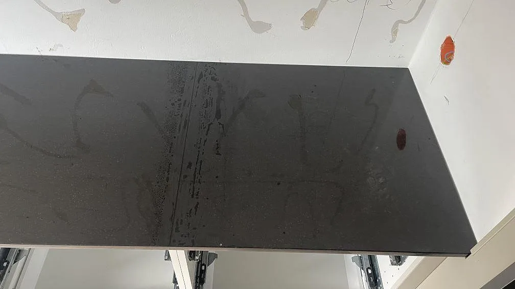 Närbild på den högra bänkskivan i polerad Nero Assoluto granit, monterad mot vägg i köket i Skurup.