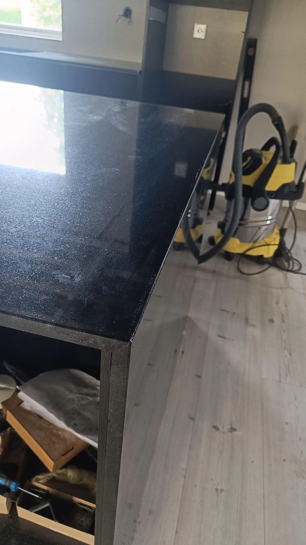 Närbild av polerad köksbänkskiva i Nero Assoluto granit med tunn kant och speglingar i Staffanstorp.