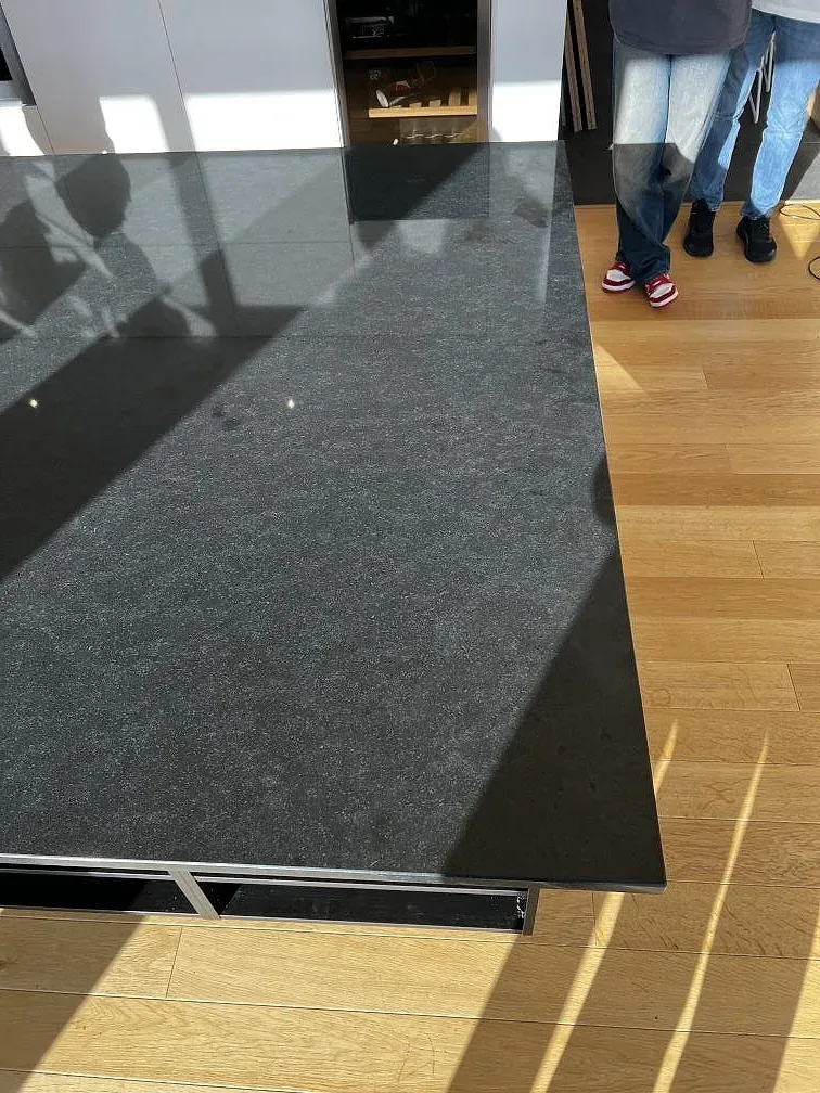 Detalj av den polerade svarta ytan i Nero Assoluto granit på en installerad köksö i Torslanda.