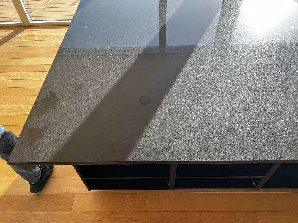 Närbild på installerad köksö i Nero Assoluto granit med polerad svart yta och raka kanter i Torslanda.