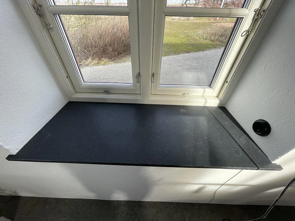 Svart Nero Assoluto-granit som fönsterbänk med utsikt över trädgård, matt yta, i Tygelsjö.