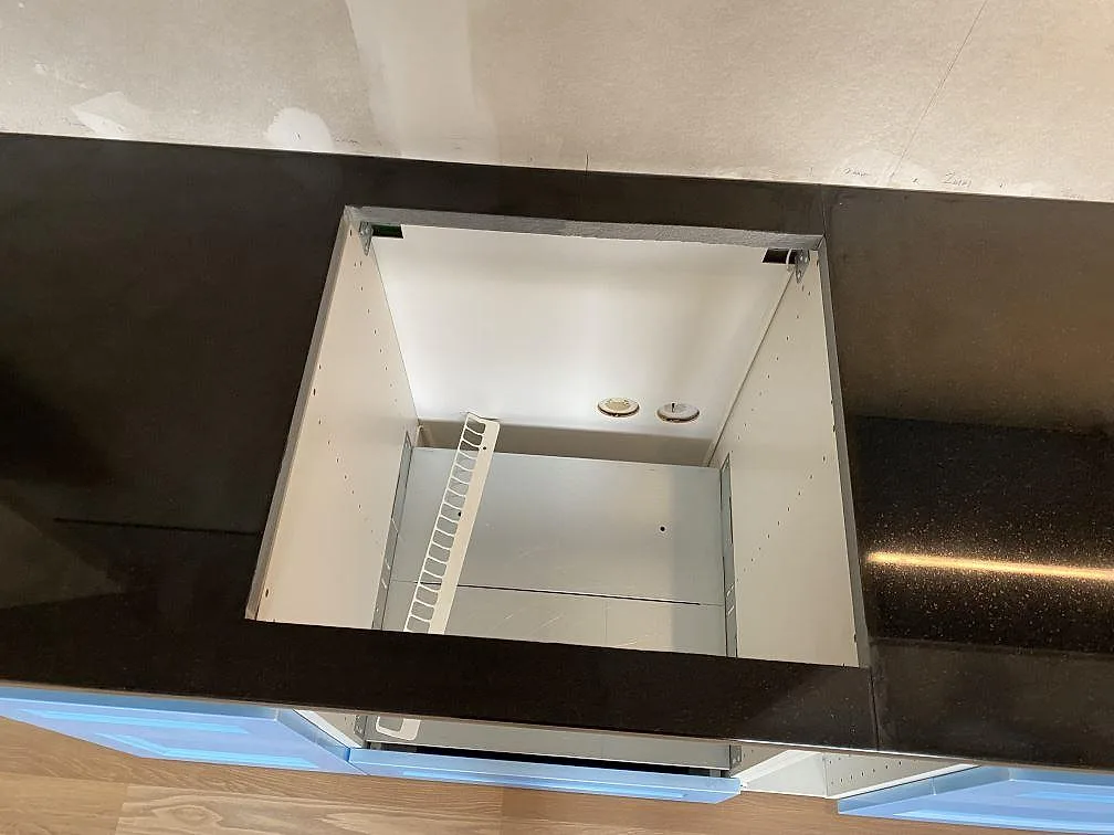 Köksbänk i polerad Nero Assoluto granit med rektangulärt urtag och blå stommar i Vänersborg.