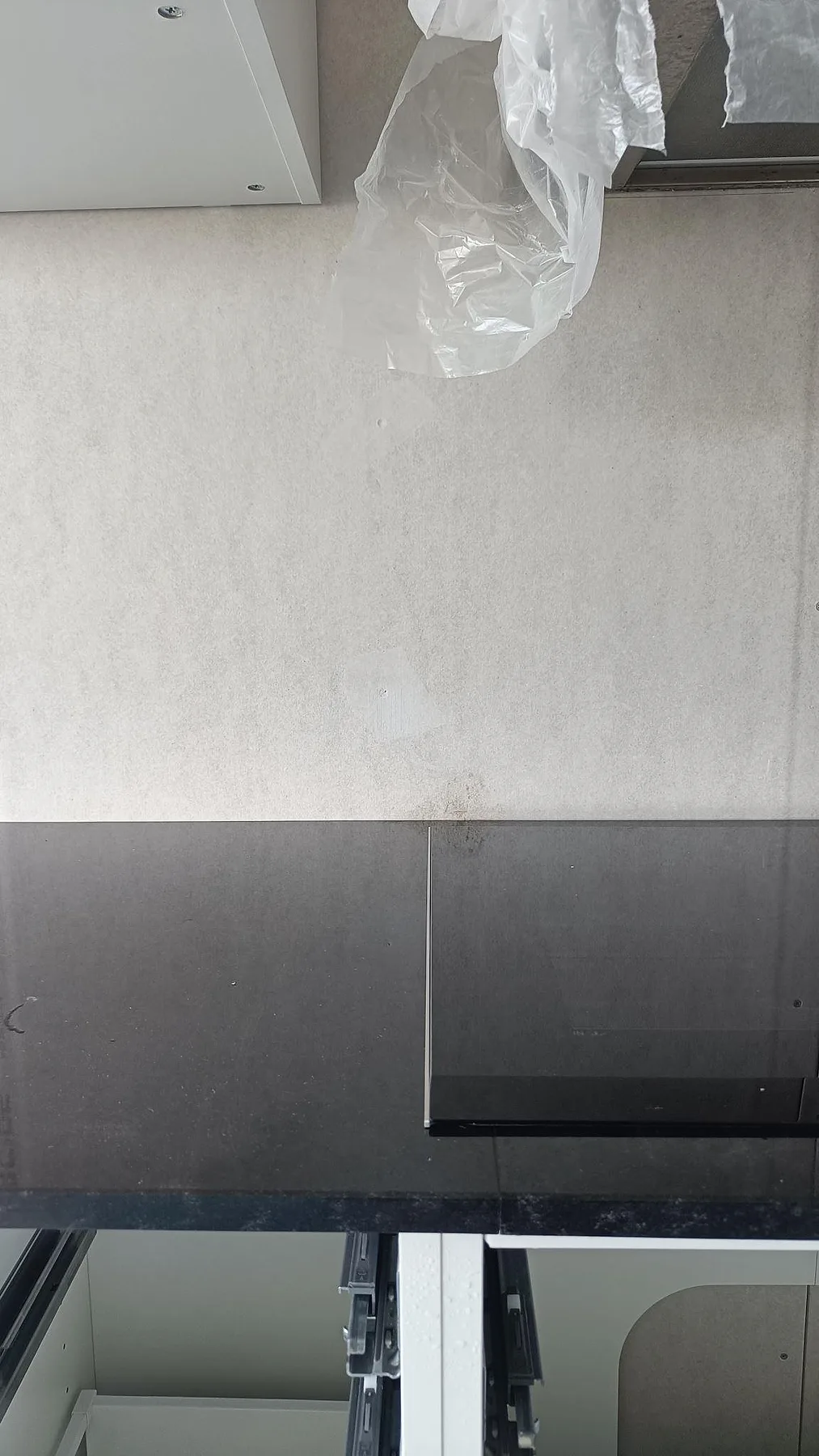 Detalj av Nero Assoluto granitbänkskiva och hällzon vid öppna köksstommar under montering i Västra frölunda.