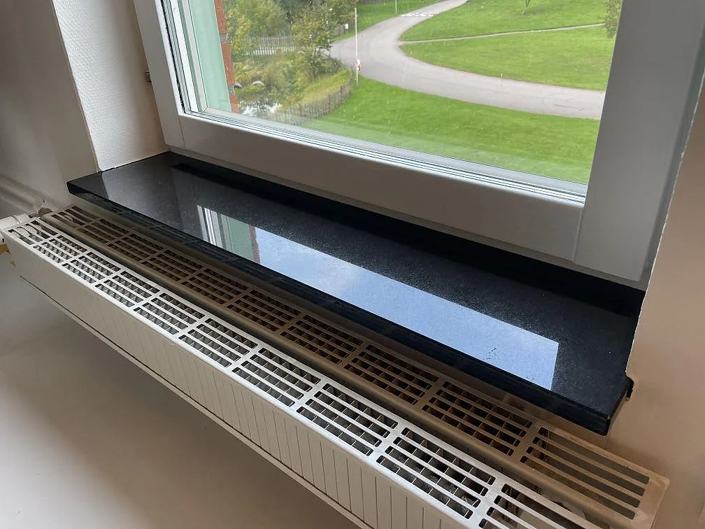 Fönsterbänk i polerad Nero Assoluto granit monterad vid köksfönster i Vellinge.
