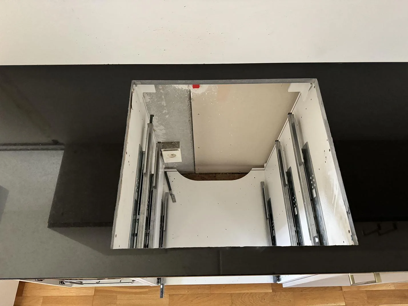 Detalj av hällöppning i svart polerad Nero Assoluto granitbänkskiva under montering i Vellinge.