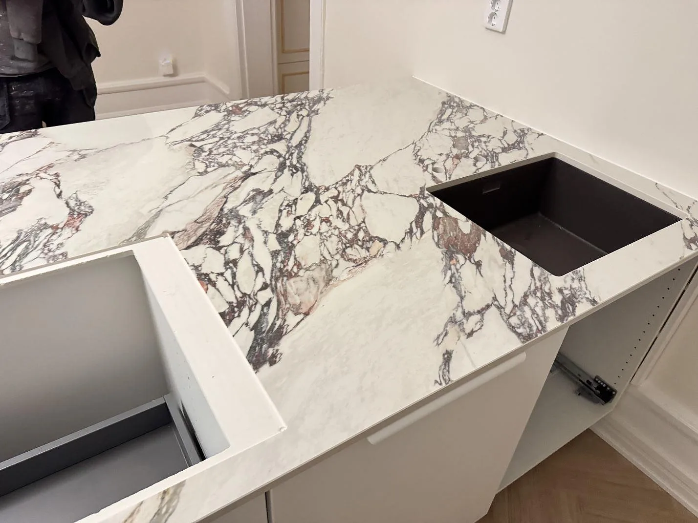 Hörnbänk i Nuovo Corso Arabescato Viola keramik med underlimmad diskho och två borrade blandarhål under montering i ett kök i Helsingborg.