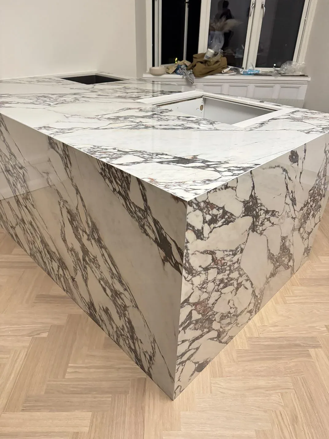 Köksö med vattenfallskant i Nuovo Corso Arabescato Viola keramik med häll infälld i skivan i ett kök i Helsingborg.