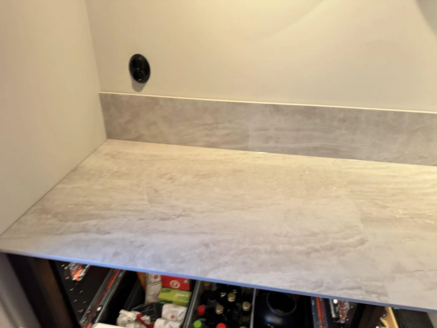 Polerad keramikbänkskiva i Nuovo Corso Taj Mahal med varm beige ådring och låg stänkkant, sedd i ögonhöjd i ett Göteborgskök.